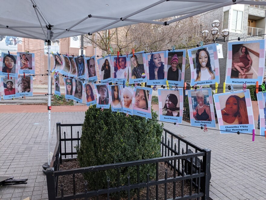 Two rows of photos of people, clipped between two pieces of string.