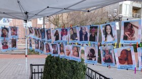 Two rows of photos of people, clipped between two pieces of string.