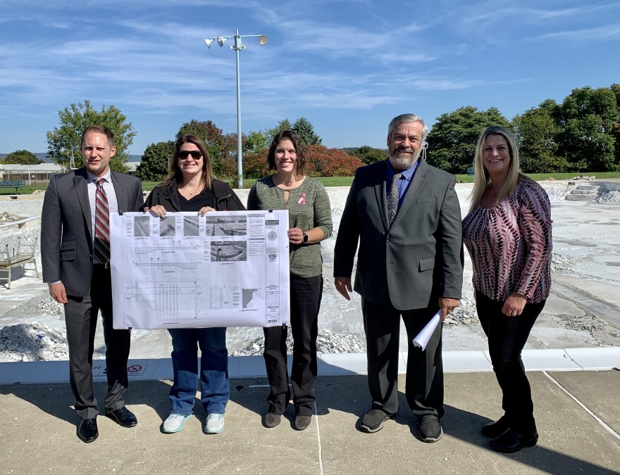 State Sen. Zach Mako, pool association treasurer Katherine Barhight Herzog, pool association secretary Jessica Barhight Rehrig, State Sen. Patrick Browne, and Slatington Mayor Jeralyn Walters Schoch stand in front of the Northern Lehigh Swimming Pool with a poster of the repairs completed so far.