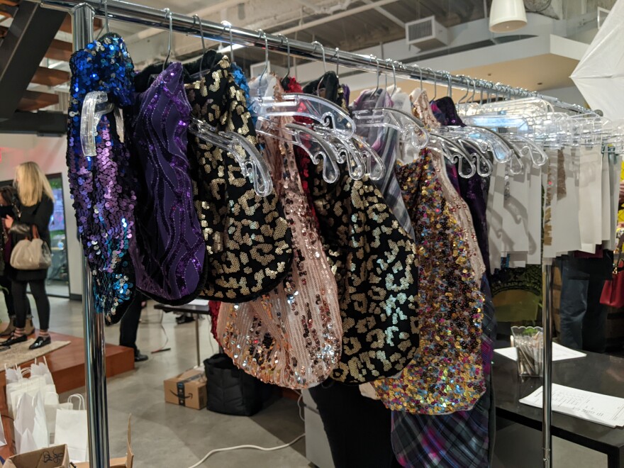 Dog coats from small to large hang on a rack. They come in various sequin colors like purples, pinks and cheetah print with sequins.jpg