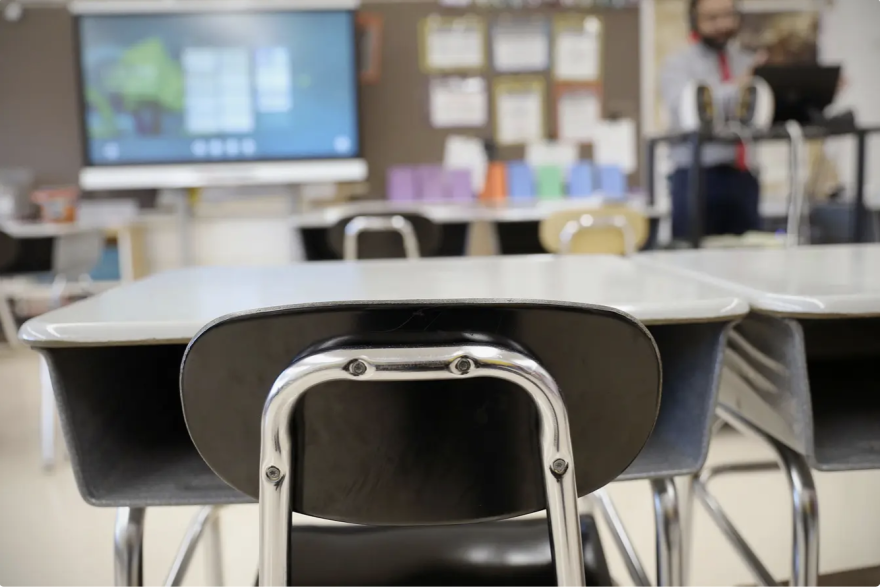 A chair and desk in a classroom.