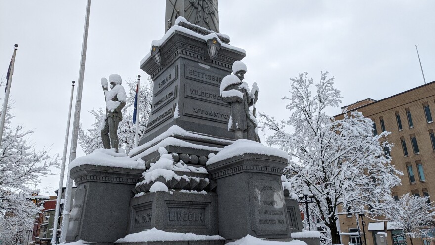 A monument to civil war soldiers and sailors covered in snow.