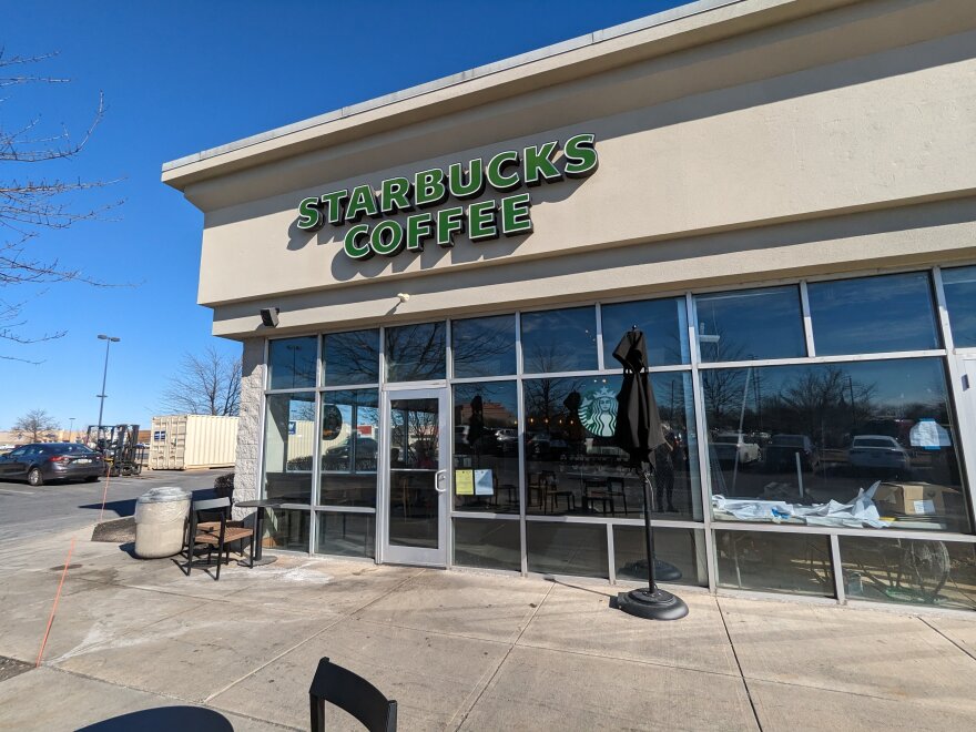 The exterior of a strip mall Starbucks from the outside