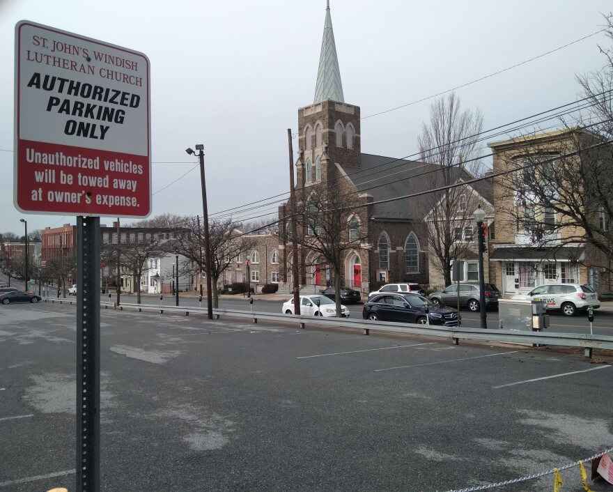 A church in the background, with a parking lot in the foreground and a sign that reads "St. John's Windish Lutheran Church Authorized Parking Only."
