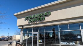 The exterior of a strip mall Starbucks from the outside