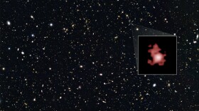 This image shows a 'close-up' of the galaxy GN-z11 as imaged by the Hubble Space Telescope, superimposed on top of another image marking the galaxy's location in the sky.