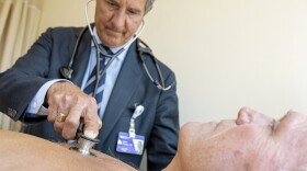 In this Monday, July 8, 2019 photo, James Thomas, a cardiologist at Northwestern Hospital in Chicago examines Dennis Calling, a retired Chicago inspector,