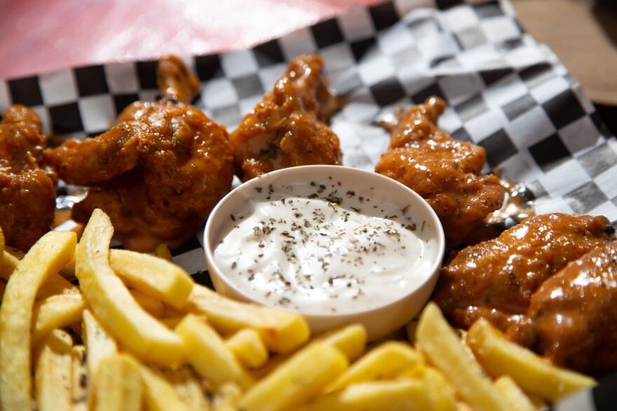 chicken wings and fries arranged around a container of creamy white sauce