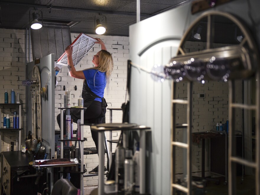 A woman replaces an air filter in Greeley, Colo., in 2020. Chemical health experts recommend homeowners check air filters and indoor air quality to prepare for any chemical hazards in the future.