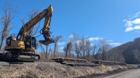 A specialized excavator helps take apart and stack sections of track.