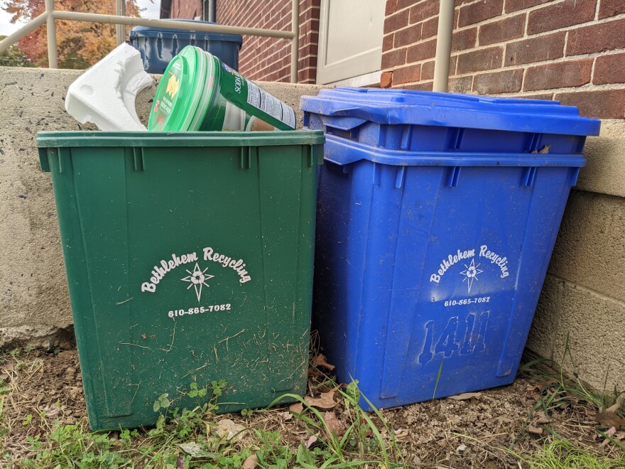 two Bethlehem recycling bins, one green and full of packaging to recycle and one blue with the lid on.