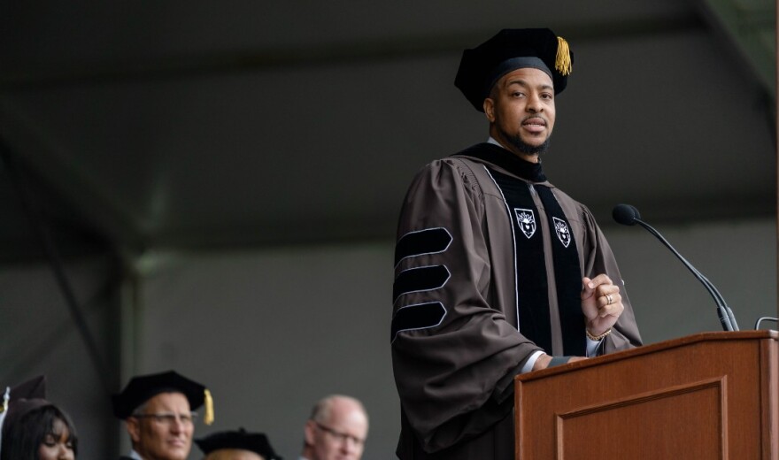 CJ McCollum in graduation regalia speaking at a Lehigh University podium