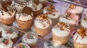 Cupcakes of different flavors - chocolate, vanilla caramel, sprinkles sit in a display case