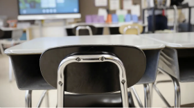A chair and desk in a classroom.