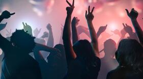 Nightlife and disco concept. Young people are dancing in club.
