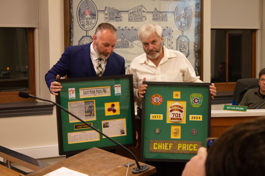 John Price holding retirement plaques