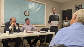 Sean Ziller, stands and holds up a map of south side business locations.jpg