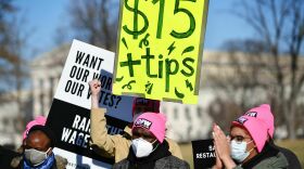 An activist holds a placard demanding a $15/hour minimum wage and tips for restaurant workers at the House Triangle of the U.S. Capitol in February.
