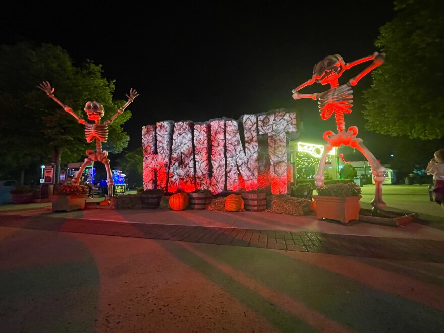 sign that reads haunt with giant skeletons on either side