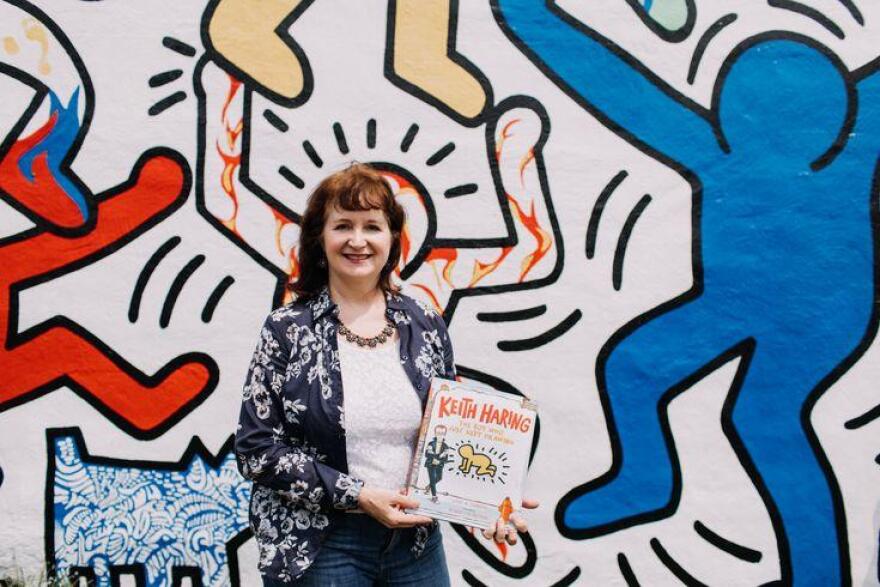 Kay Haring in front of Keith Haring mural