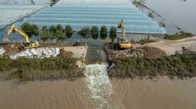 Rescuers dig a spillway to release flood waters after heavy rainfall in China's northern Shanxi province in 2021. A new report finds that human-caused climate change made the floods about twice as likely.