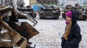 People look at destroyed Russian military vehicles on display in central Kyiv on a snowy afternoon in the capital city on January 9.