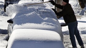 FILE - A resident of the Greenfield neighborhood of Pittsburgh brushes snow off a car, Tuesday morning,  Feb. 22, 2011, after more than 8 inches fell overnight in the area.