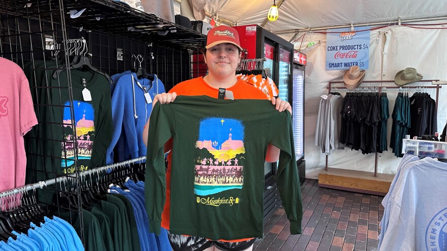 A man holding up a shirt at Musikfest